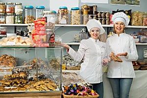 Happy women staff offering sweets