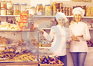 Happy women staff offering sweets