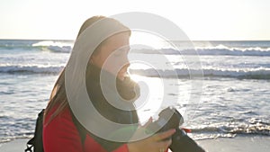 Happy women taking pictures and looking into the camera at the beach.