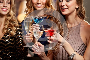 happy women toasting drinks at night club