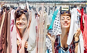 Happy women at weekly flea market - Female friends having fun together shopping cloth on sunny day - Millenial lifestyle concept photo