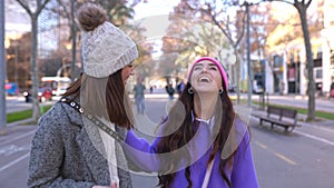 Happy women in winter clothes having fun walking in city street