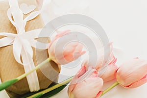 Happy womens day. Pink tulips with ribbon on white background with gift box. Stylish tender image. Happy womens day. Greeting card