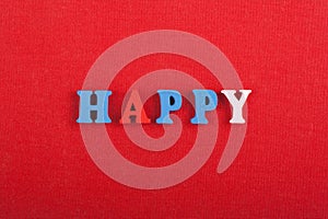 HAPPY word on red background composed from colorful abc alphabet block wooden letters, copy space for ad text. Learning english