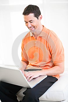 Happy work at home male working on laptop smiling