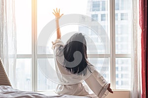 Happy work-life quality balance concept with easy lifestyle Asian girl on bed have a good day waking up from good sleep