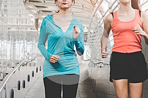 Happy work out to burn calories for good health. women invite friends jogging together in the city in the morning