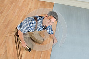 Happy worker assembling new laminate floor