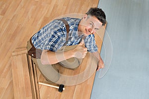 Happy worker assembling new laminate floor