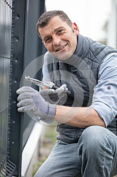 happy worker installing welded metal mesh fence