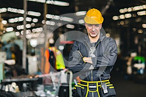 Happy worker, portrait handsome labor arms folded with safety suit tools belt and radio service man in factory