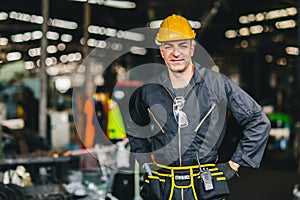 Happy worker, portrait smile handsome labor with safety suit tools belt and radio service man in factory