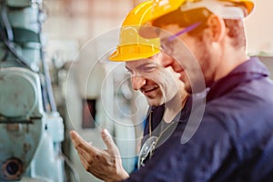 Happy worker, smiling industrial technician engineer enjoy working together with coworker