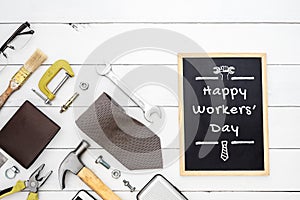 Happy Workers` Day background concept. Flat lay of construction blue collar handy tools and white collar`s accessories over wood