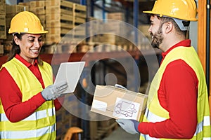 Happy workers talking while doing stock inventory inside warehouse - Focus hand holding tablet