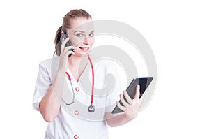 Happy working woman doctor using phone and tablet