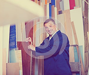 Happy workman standing with plywood pieces