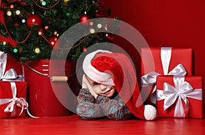 Happy xmas and New Year. Portrait of child in Santa red hat waiting for Christmas gifts.