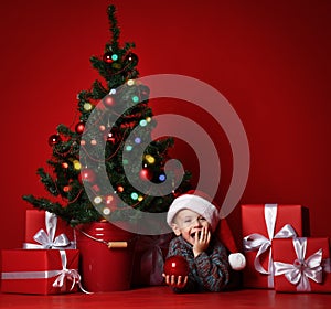 Happy xmas and New Year. Portrait of child in Santa red hat waiting for Christmas gifts.
