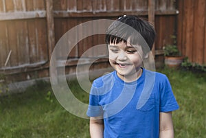 Happy 6-7 year old boy smiling and showing his missing teeth. Cute child boy lost front milk tooth. Kid having fun playing with