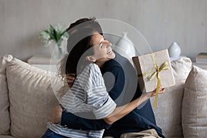 Happy young 30s latina woman thanking husband for gift.