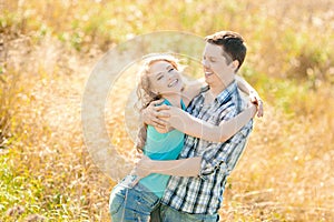 Happy young adult couple in love on the field. Two, man and wom