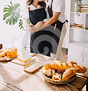 Happy young adult couple making breakfast and drinking coffee together in cozy home kitchen in morning at home. Preparing meal and