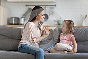 Happy mother and cute child enjoy talking relaxing on sofa photo