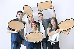 Happy young adults holding up copyspace placard thought bubbles