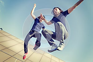 Happy young adults jumping on a terrace