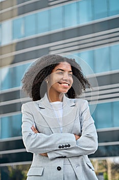 Happy young African American business woman standing in city feeling proud.