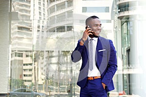 Happy young african american businessman with cell phone