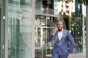 Happy young african american businessman talking on cell phone