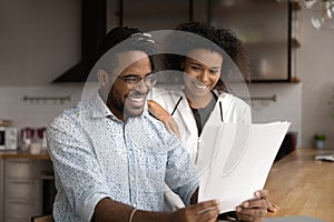 Happy young african american couple getting letter with good news.