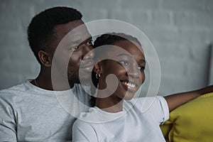 happy young african american couple looking away together