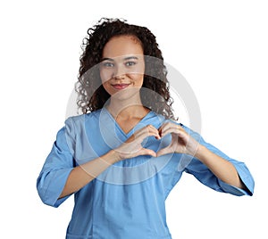 Happy young African-American doctor making heart with hands on white background