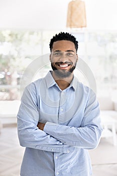 Happy young African American entrepreneur man standing with crossed arms