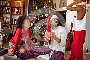 Happy African American Family exchanging gifts in front of decorated Christmas tree