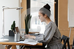 Happy young African American female office employee wearing glasses