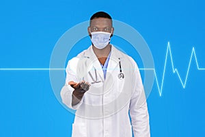 Happy young african american guy doctor in white coat, protective mask hold abstract virtual heart on hand