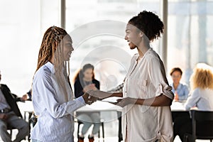 Happy young african american leader shaking hands with biracial colleague.