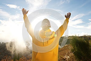 Happy young african american man with arms raised in air outdoors