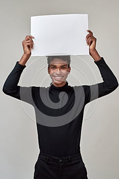 Happy young african american man holding broadside above head photo