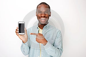 Happy young african american man holding mobile phone and pointing to screen