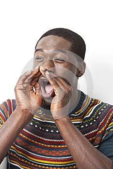 Happy young African American man shouting against white background