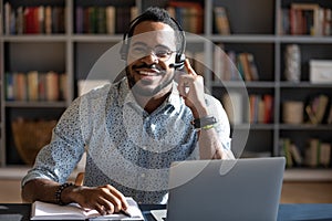 Happy young african american man wearing headset, looking at camera.