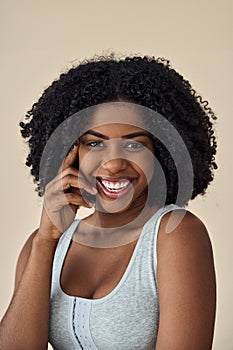 Happy young African American woman beauty model at beige background. Portrait.