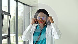 Happy young african american woman doctor wearing white medical coat and stethoscope looking at camera. Smiling female