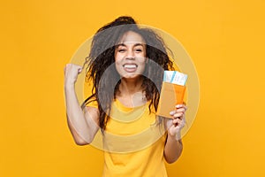 Happy young african american woman girl in casual t-shirt posing isolated on yellow background. People lifestyle concept