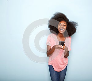 Happy young african american woman holding smart phone